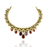 Gold-tone necklace set with black enamel detailing, sparkling clear accents, deep orange teardrop stones and matching statement earrings.