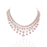 Elegant pink American diamond necklace set with matching long earrings featuring blush pink stones, floral drop accents, and a rhodium-plated finish for bridal and festive wear.