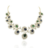 Blue and green American Diamond necklace set with gold-tone floral vine detailing, sparkling clear stones and matching long statement earrings.
