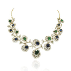 Blue and green American Diamond necklace set with gold-tone floral vine detailing, sparkling clear stones and matching long statement earrings.