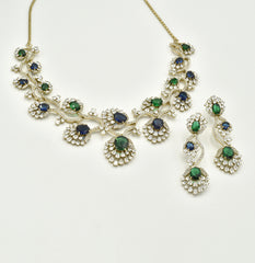 Blue and green American Diamond necklace set with gold-tone floral vine detailing, sparkling clear stones and matching long statement earrings.
