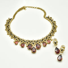 Gold-tone necklace set with black enamel detailing, sparkling clear accents, deep orange teardrop stones and matching statement earrings.