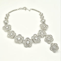 White floral American Diamond necklace set with round and baguette-cut clear stones in a silver-tone finish with matching flower earrings.