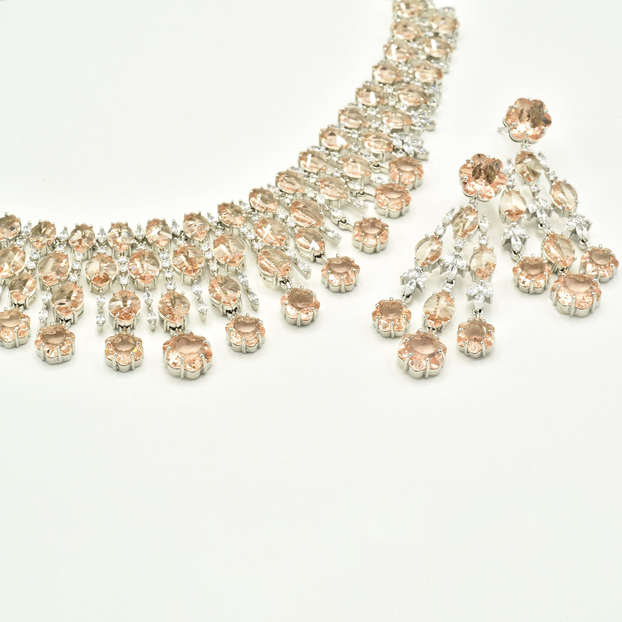 Elegant champagne American diamond necklace set with matching long earrings featuring  floral drop accents, and a rhodium-plated finish for bridal and festive wear.