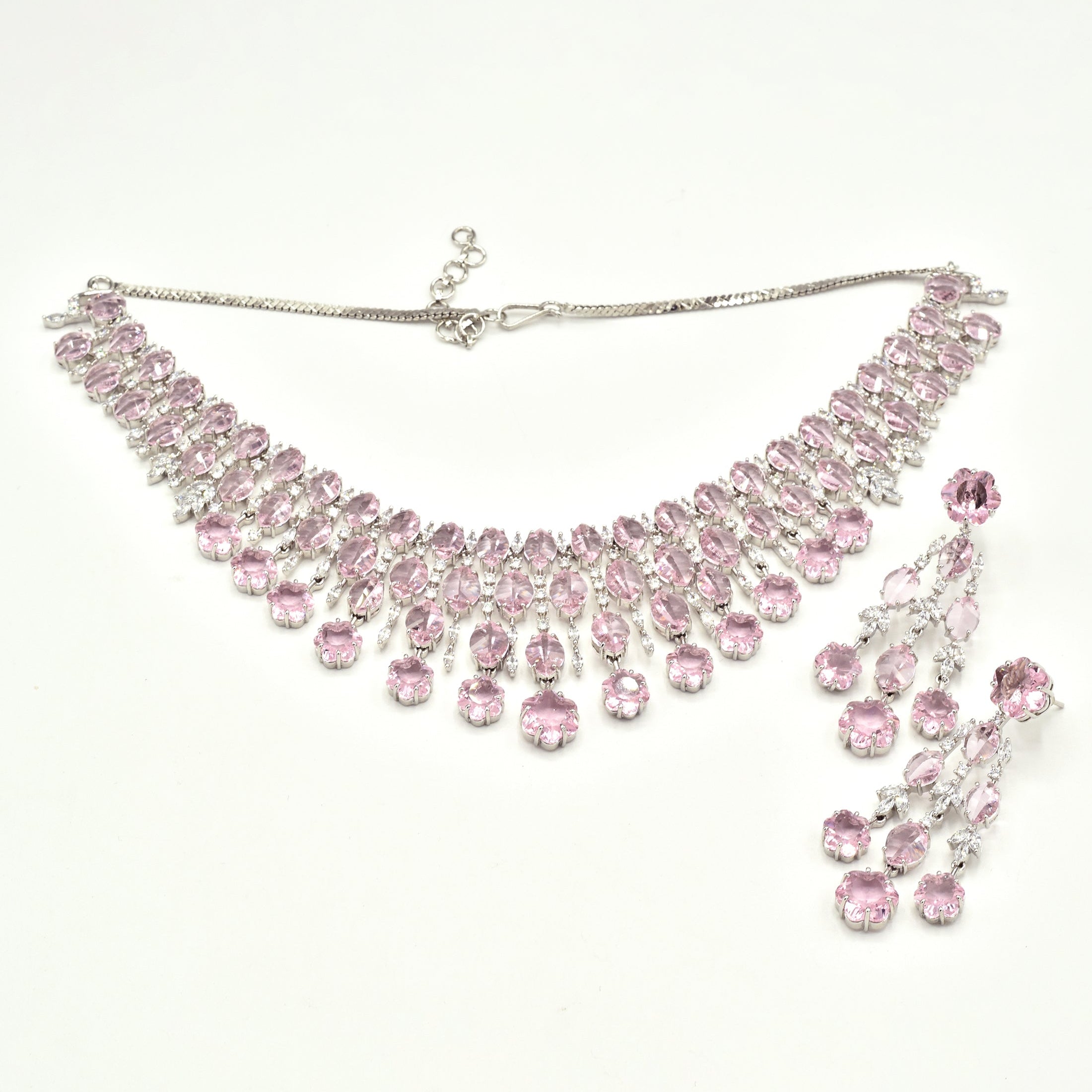 Elegant pink American diamond necklace set with matching long earrings featuring blush pink stones, floral drop accents, and a rhodium-plated finish for bridal and festive wear.