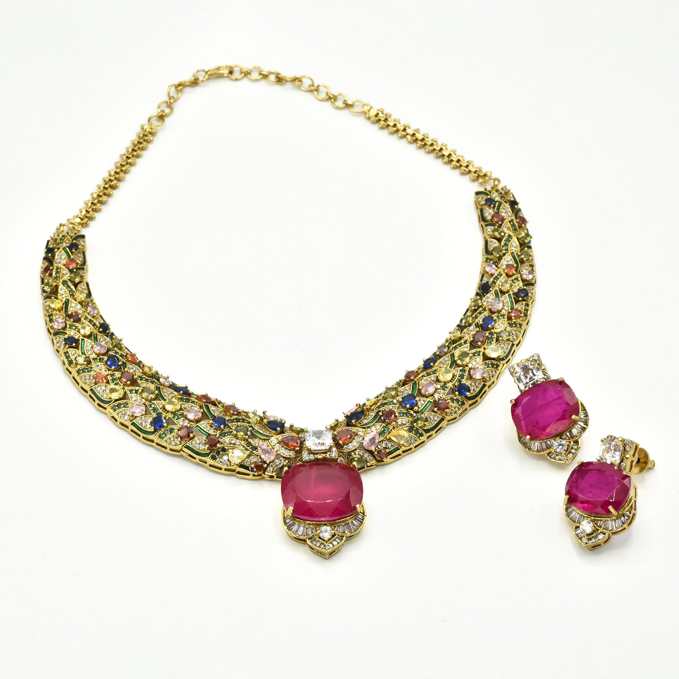 Gold-tone multicolor statement necklace set with intricate jewel-tone stones, bold deep pink center stone and matching pink statement earrings.