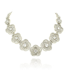 White floral American Diamond necklace set with round and baguette-cut clear stones in a silver-tone finish with matching flower earrings.